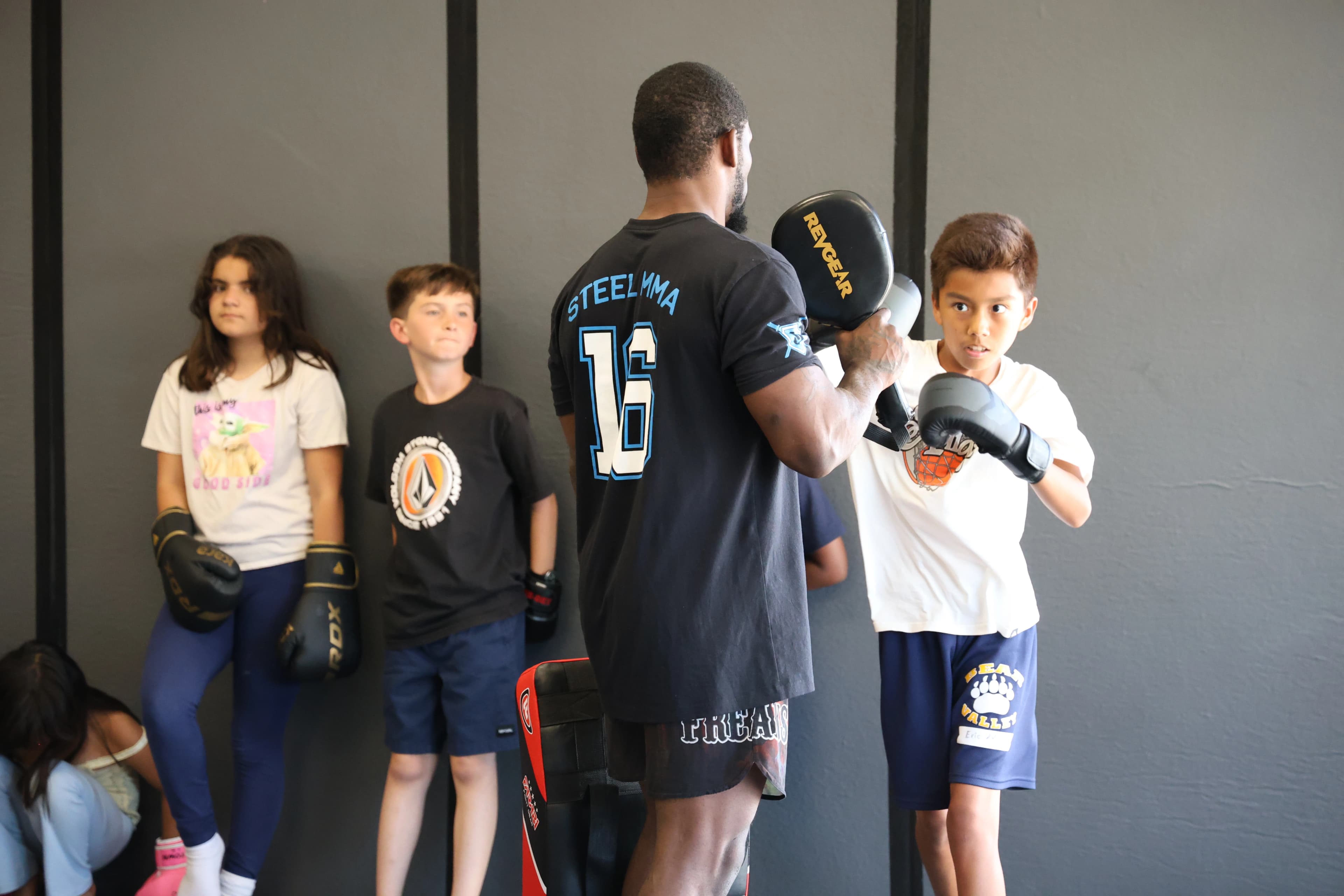 Big kids martial arts class with instructor demonstrating techniques