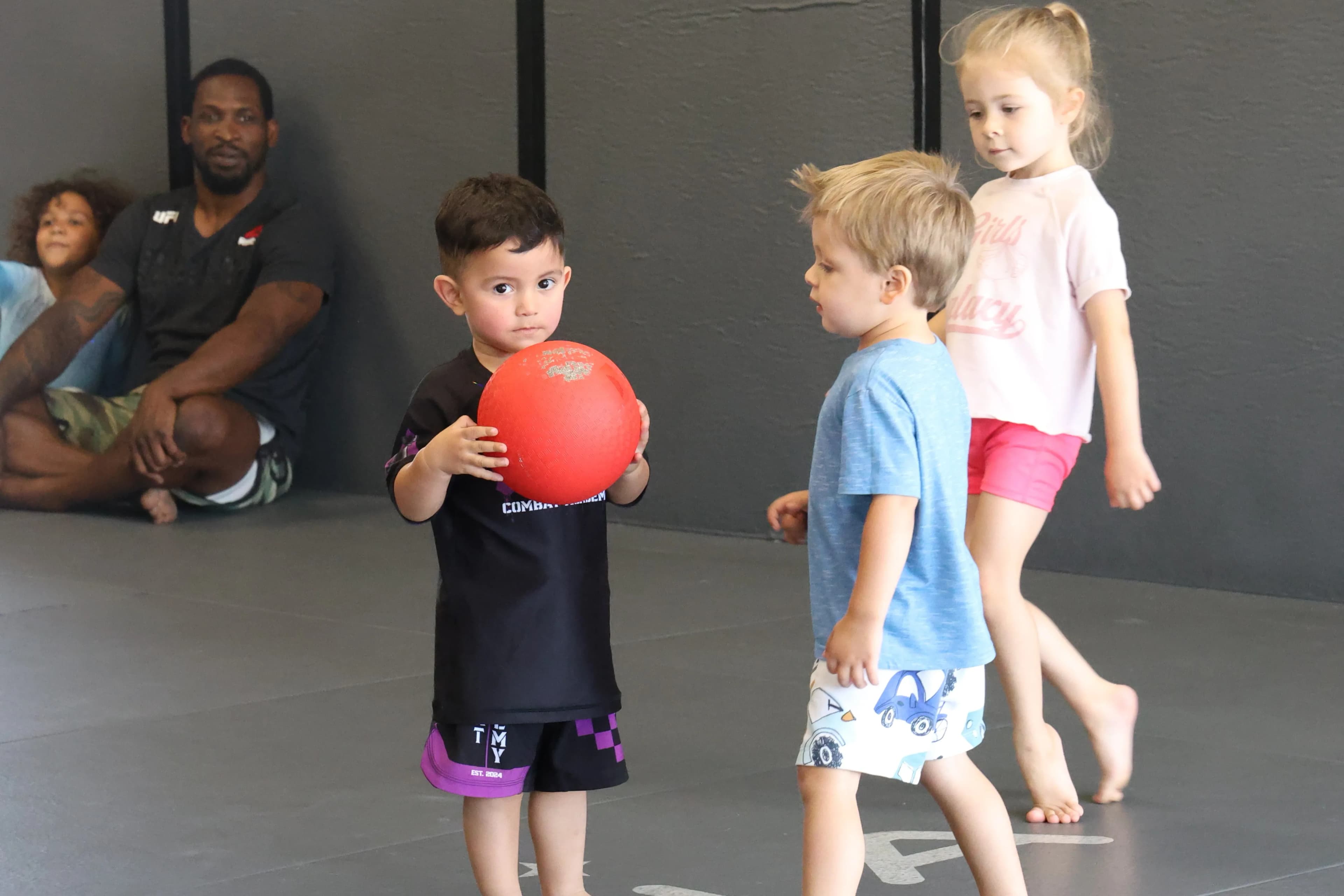 Kids playing martial arts games in a class setting with instructor leading the group